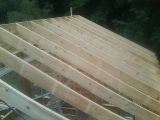 New roof rafters set over an addition before sheathing in Downey