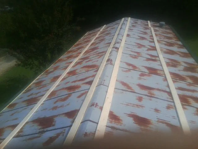 Rusted metal roof panels with new wood purlins before replacement — Storm Damage Roof Repair in Downey by Roofing Brothers