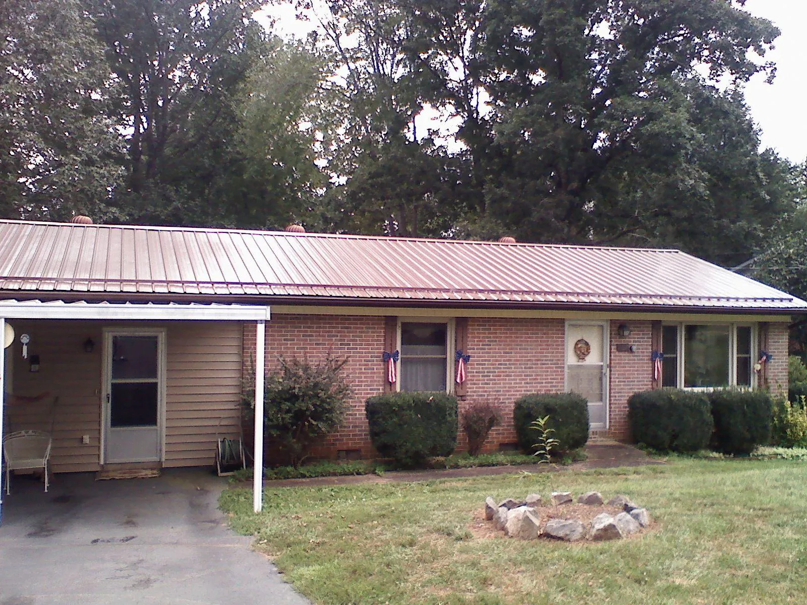 Bronze metal roof and carport on a brick ranch home — Roof Repair work by our crew in Downey